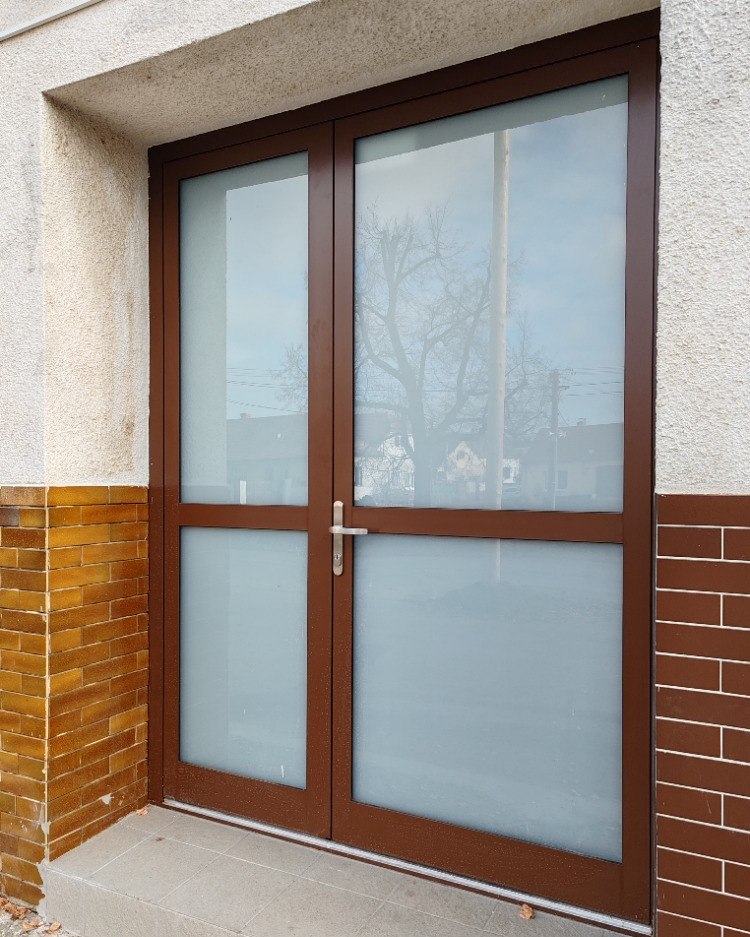 Dvoukřídlé hliníkové dveře v tmavě hnědé barvě s mléčným sklem
